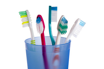 Toothbrushes in blue glass isolated on white background