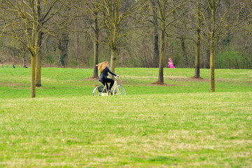 Blonde girl on bicycle. Open air life. Long hair in the wind.