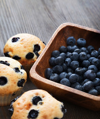 muffin with blueberries on a wooden table. fresh berries and sweet pastries on the board.