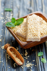 Bars with sesame in honey glaze and a scoop with sesame seeds.