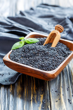Black sesame seeds in a wooden bowl.