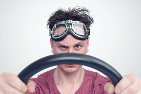Man in stylish goggles with steering wheel, car driver concept