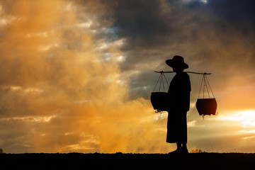 farmer walking at sunset.