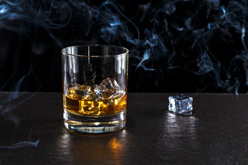 glass of whiskey with ice on a dark background