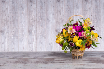Beautiful bouquet of bright flowers in basket 