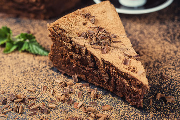 chocolate cake with Candies and cup of coffee,Chocolate cake with a cut piece and blade on gray background,closeup,Dark chocolate cake,vegan chocolate cake,Tasty chocolate cake on wooden background