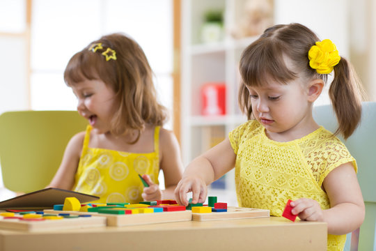 Preschool children playing with educational sorter toys in classroom, kindergarten or home