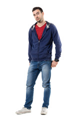 Fototapeta premium Friendly young handsome guy in blue sweatshirt looking at camera. Full body length portrait isolated over white studio background.
