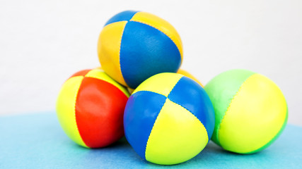 stack of colorful juggling balls on blue table