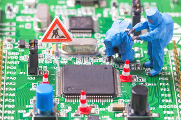 Miniature computer engineers working on a computer circuit board