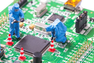 Miniature computer engineers working on a computer circuit board