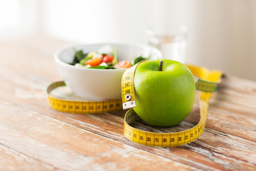 close up of green apple and measuring tape