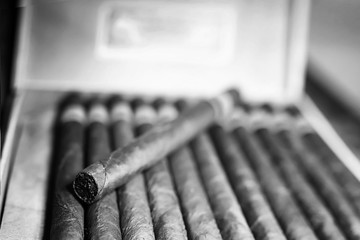 Retro styled photo of large box of Cuban cigars on a wooden table