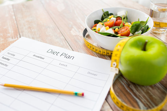 close up of diet plan and food on table
