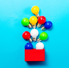 photo of colorful bulbs and red box on the wonderful studio blue background