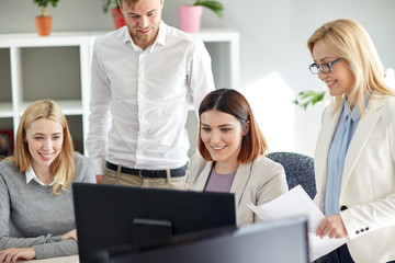 happy business team with computer in office