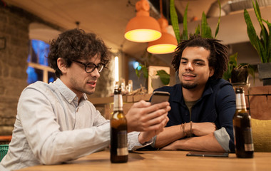men with smartphones drinking beer at bar or pub