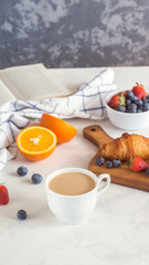Obraz na płótnie Canvas Morning breakfast. Croissant with berries and cup of coffee, on white background