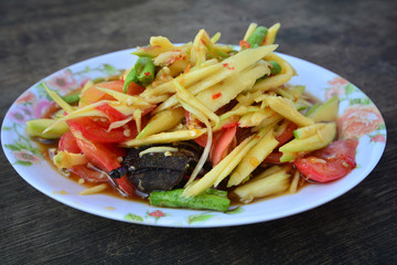 Papaya salad Thai cuisine spicy delicious on wooden plate , SomTam