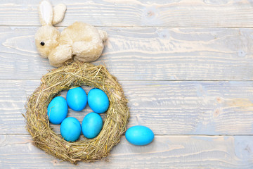 traditional eggs painted in blue color inside woven straw wreath