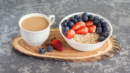 Obraz na płótnie Canvas Steel cut oatmeal porridge with fresh berries and cup of coffee for breakfast
