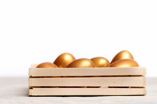 traditional easter golden eggs in wooden box isolated on white