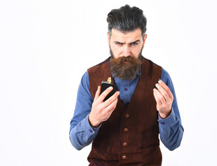 bearded man holding perfume with serious face