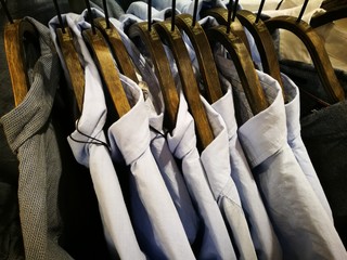 Modische Freizeithemden auf Kleiderbügeln aus Holz in einem Jeansladen in der Shopping Mall in...