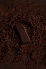 Close up of a chocolate piece in chocolate powder on a table