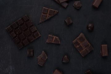 Top view of crushed dark chocolate bar with sweets