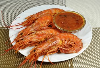 Four langoustines, stewed in saute sauce, on white plate
