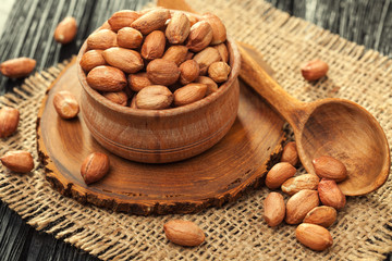 Peeled peanuts in a wooden bowl on an old burlap
