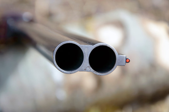 Muzzle of double-barreled shotguns. Shotgun pointed at me - macro shooting. Hunting rifle takes aim at the victim. Eyes on the target.