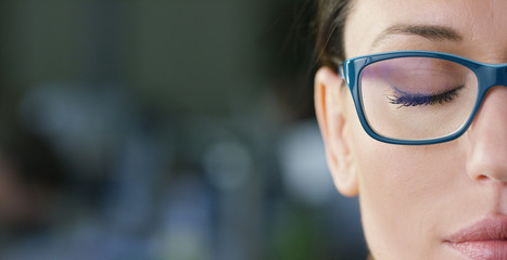 Portrait of a beautiful girl with glasses, with green eyes, shot close-up, on a blurred background....