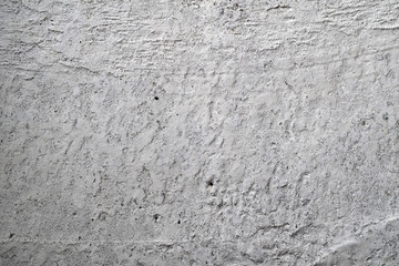 Gray concrete wall with white abrasion and small holes.