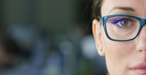 Portrait of a beautiful girl with glasses, with green eyes, shot close-up, on a blurred background....