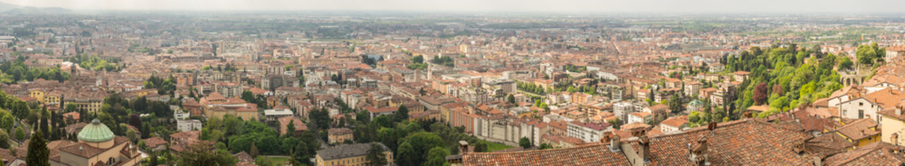 Fototapeta na wymiar Bergamo, Italy. Landscape on the old city (upper town), the city center, the group of old towers and the new city. Shot from the old fortress.