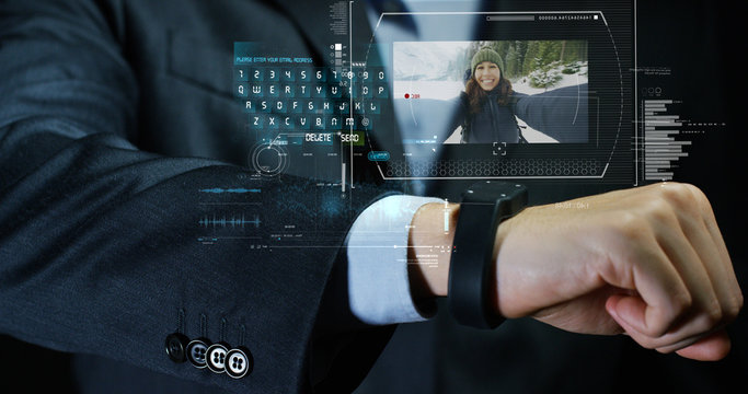 A man answers the wife who smiles and waves from the phone that appears in hologram clock futuristic and technological. Concept: holiday, communication,family, technology, augmented reality and future