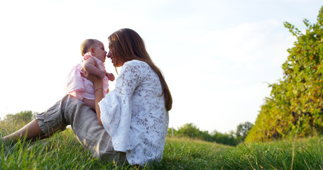 in a beautiful and happy sunny day , a mother and baby little girl play and are happy immersed in the colorful nature and happiness , the baby laughs happy . concept of happiness , love and nature.	