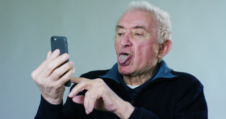 An old man listening to music with headphones and dancing by moving your hands to the beat.