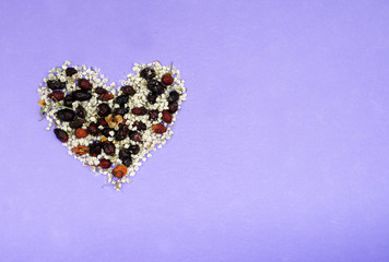 Heart from dried flowers, pink, violet purple background