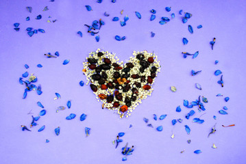 Heart from dried flowers, pink, violet purple background