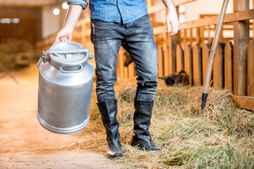 Close-up view on the legs of farmer working with hay at the animal barn