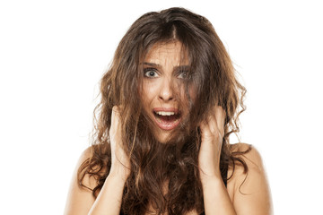 A young shocked woman with a messy long hair