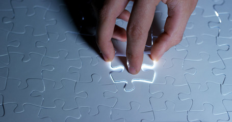 A creative completes the black or white light puzzle putting the last missing piece. Concept:...
