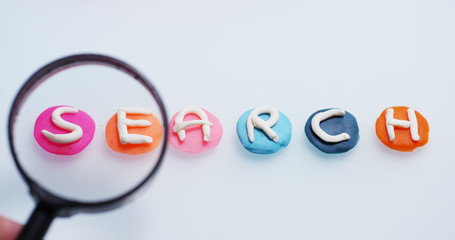 A magnifying glass hovers over the word 