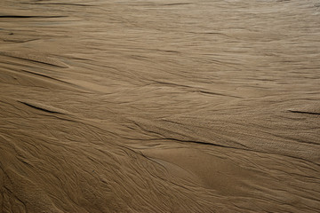 Texture of river sand with traces of water flows