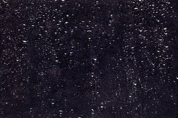 Abstract dark background with old glass texture with water drops