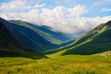 Fototapeta premium A beautiful view of the mountains of the Caucasus. The clouds in the blue sky.