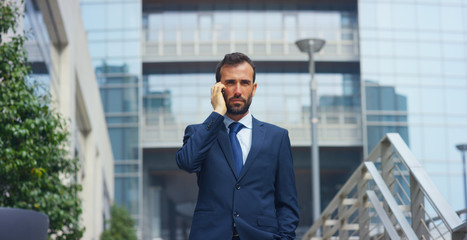 Fototapeta premium On escalators, a businessman answers the phone, send messages and smiles for the beautiful job news. Concept: technology, telephony, business trips, business. 